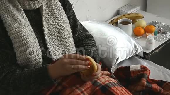 穿毛衣的生病女孩躺在床上吃香蕉视频的预览图
