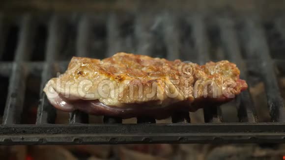 烤牛排特写在烟雾的背景下多汁的大块牛肉或小牛肉烧烤餐厅菜肴美味视频的预览图