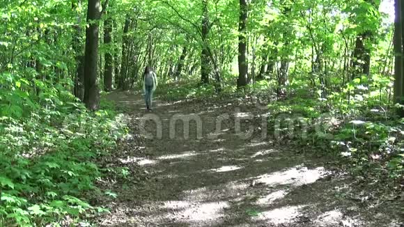 迷人的少年女孩在美丽的春天公园散步时用手机说话视频的预览图