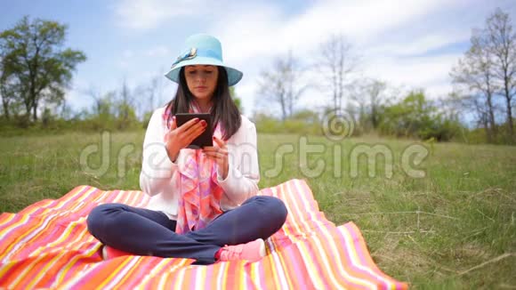 迷人的微笑的年轻女性在智能手机上阅读电子书视频的预览图