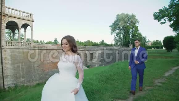 新婚夫妇在古堡附近散步和摆姿势视频的预览图