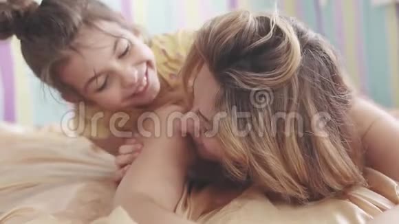年轻的妈妈和她的小女儿拥抱着笑视频的预览图