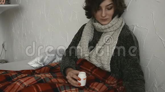 生病的女人躺在床上毯子下面放着药丸视频的预览图