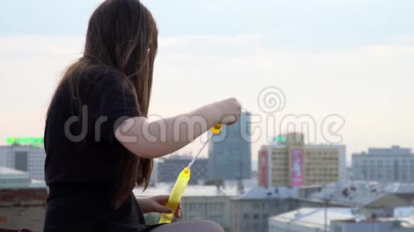这个女孩在高楼的屋顶上花钱那个长头发的女孩在楼顶上冒泡泡可爱的视频的预览图