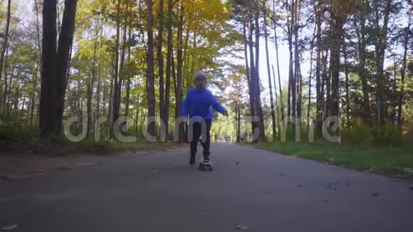 滑板少年儿童在秋季公园户外滑冰视频的预览图
