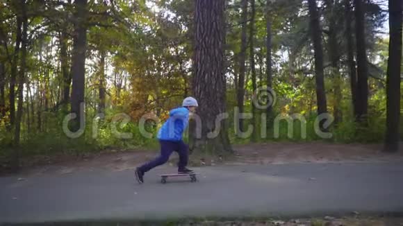 滑板少年儿童在秋季公园户外滑冰视频的预览图