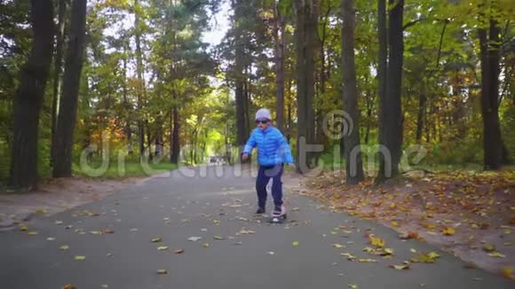 儿童骑滑板男孩骑滑板户外秋季公园视频的预览图