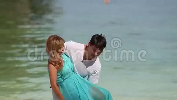 强壮的帅哥把金发亚洲女孩抱在怀里视频的预览图