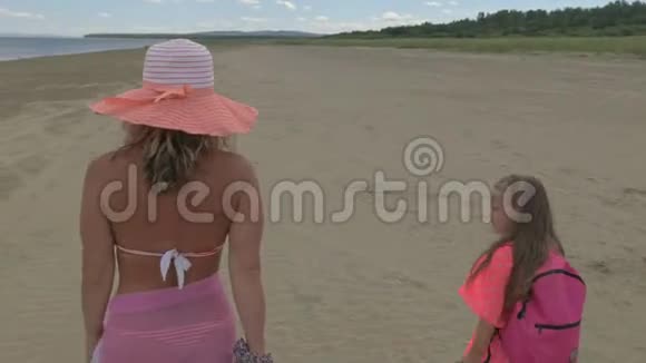 母亲带着两个女儿在海滩上散步视频的预览图