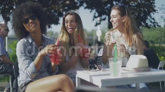 时髦的年轻女孩在外面喝酒视频的预览图