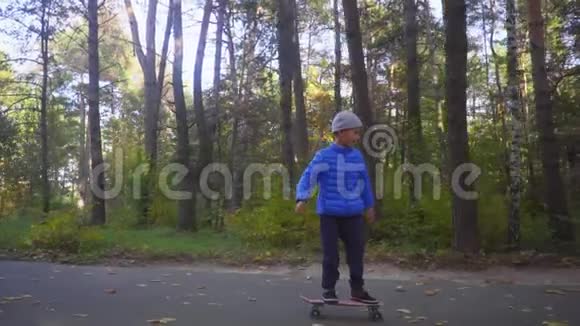 儿童骑滑板男孩骑滑板户外秋季公园视频的预览图