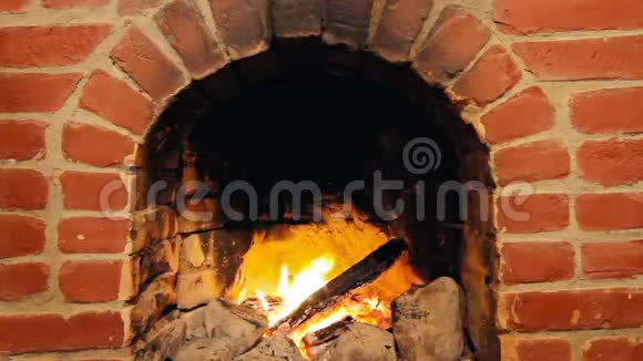 一个人在烧砖的壁炉里用耙子搬木头视频的预览图