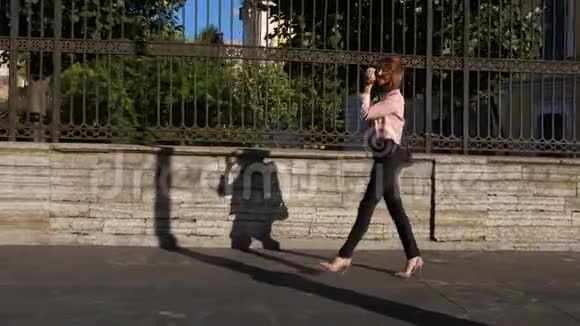 美丽的年轻女子走在城市大街上视频的预览图