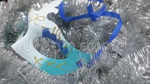 一个银质的狂欢节面具的特写旋转圣诞节的背景金塞尔视频的预览图