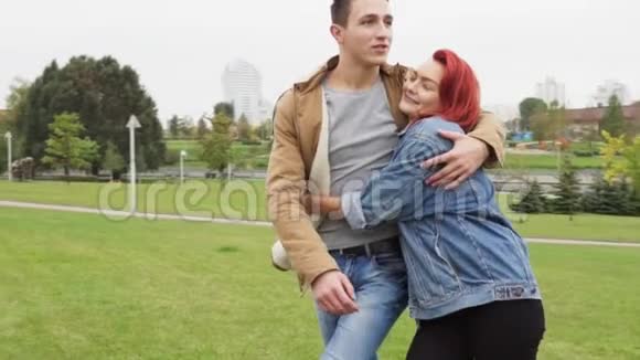 快乐的男人和女人在城市公园里散步和拥抱视频的预览图