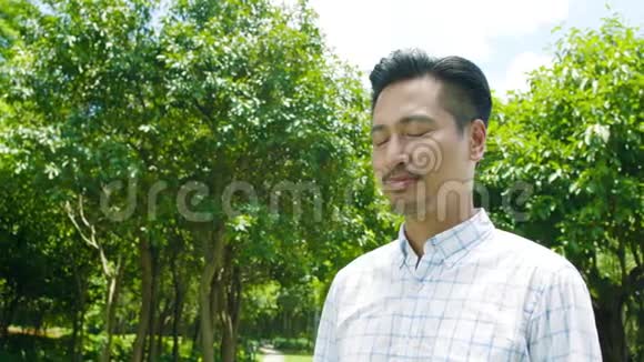 亚洲男子深呼吸微笑和享受自然户外慢动作视频的预览图