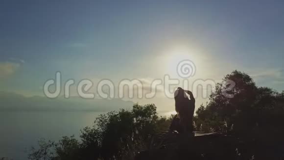 镜头飞过坐着的女孩触摸岩石上的头发视频的预览图