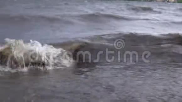 暴风雨过后带有白色泡沫的脏浪把垃圾带到岸边视频的预览图