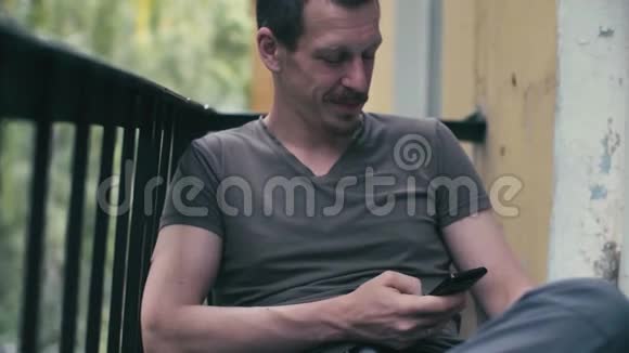 一个男人在智能手机上滚动的肖像视频的预览图