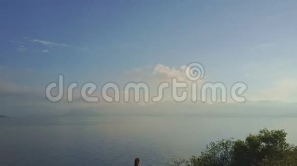 空中全景海洋和女人坐在帕德马萨纳的姿势视频的预览图