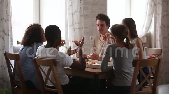 快乐的多种族的年轻朋友谈论吃比萨饼分享咖啡馆视频的预览图
