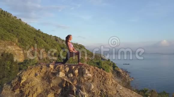 苗条的金发女孩站在石头上的战士姿势对抗山海视频的预览图