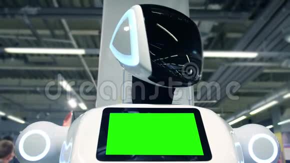 机器人上的绿色屏幕一个新的现代白色机器人的肖像机器人转过头看着摄像机视频的预览图