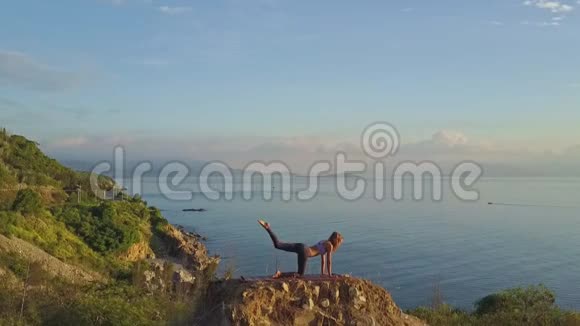 早上在陡峭的悬崖上做练习的女孩视频的预览图