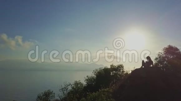 空中观景女孩剪影放松在悬崖在晨曦视频的预览图