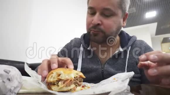 在快餐店吃汉堡的男人视频的预览图