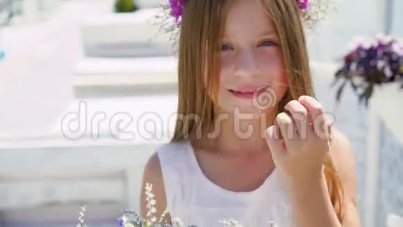 快乐的小女孩带着一束鲜花在海湾酒吧的镜头前微笑4K视频的预览图