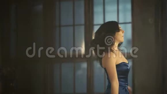 穿着豪华晚蓝色连衣裙的女孩在旋转跳舞和唱歌视频的预览图