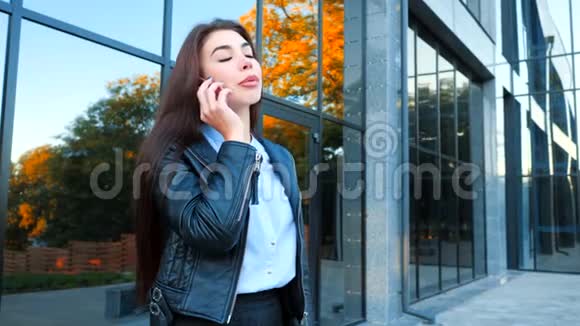 有智能手机的商务女性靠近办公楼女孩用手机交谈美丽美丽视频的预览图