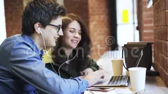 年轻夫妇亲吻并在咖啡馆里看录像视频的预览图
