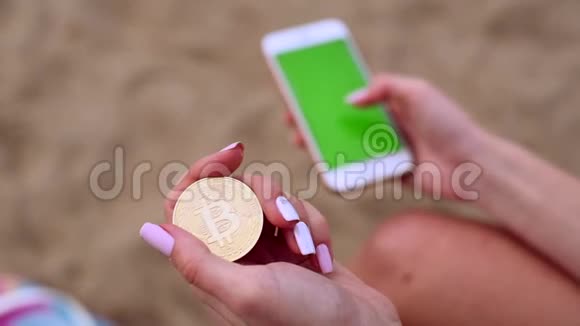 女性手拿比特币和手机视频的预览图