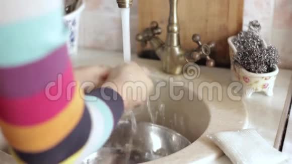 女人在厨房的水槽里洗手视频的预览图