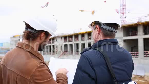 两位工程师谈论建筑工程他们看了两个纸质项目视频的预览图