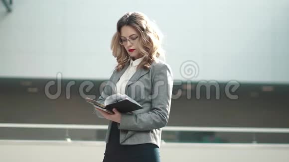 穿着西装的年轻女子看着记事本在手机上输入信息商业女性在一个视频的预览图
