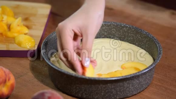 做桃派的过程女人的手把鲜桃放在面糊上视频的预览图