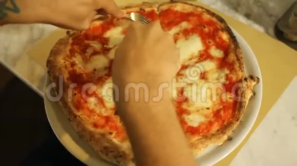 男性游客在舒适的披萨店仔细切传统的那不勒斯披萨视频的预览图