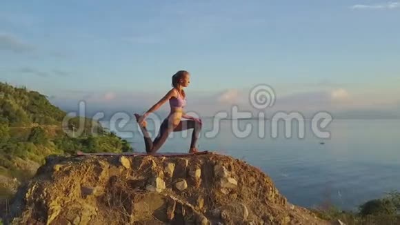 瘦小女孩做大石头上的散体动作视频的预览图