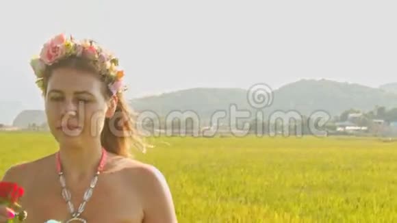 加兰海滩上的欧洲女孩闻着玫瑰落在草地上视频的预览图