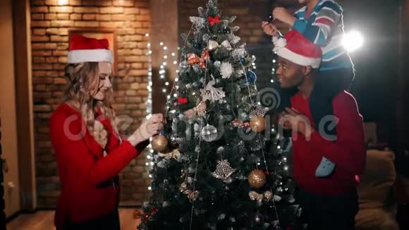 一个幸福的家庭正在装饰一棵圣诞树视频的预览图
