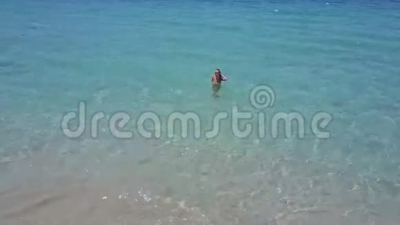 在蔚蓝的海洋中海浪拍打着女孩视频的预览图
