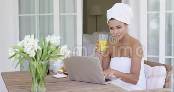 女士拿着玻璃坐着笔记本电脑视频的预览图