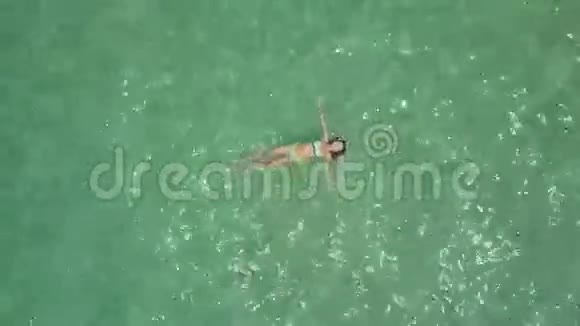 在阳光下从海洋中游泳的女孩身上移除摄像头视频的预览图