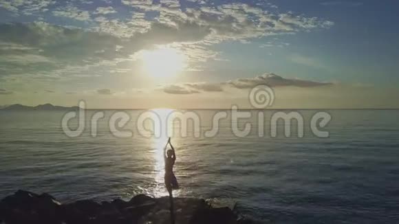 在日出无垠的大海上做瑜伽的女孩视频的预览图