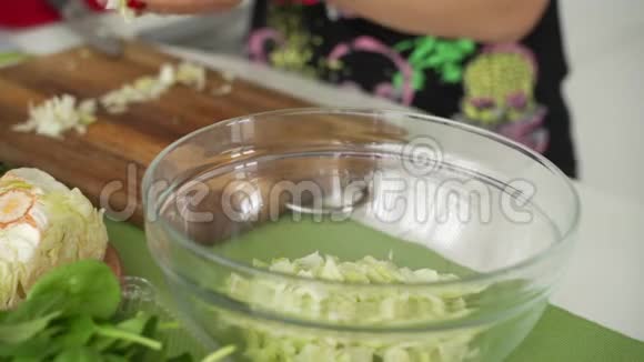 女人的手用刀切萝卜做沙拉把新鲜蔬菜放在厨房的桌子上家庭主妇做饭自然视频的预览图