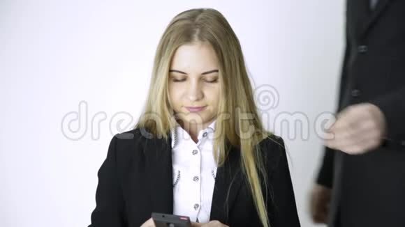 女商人在手机上自拍雇员在做了很长时间的工作后会按摩她的肩膀和脖子视频的预览图