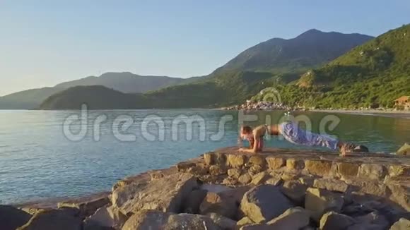 Flycam观景女孩在海岸的丘陵地带做瑜伽视频的预览图